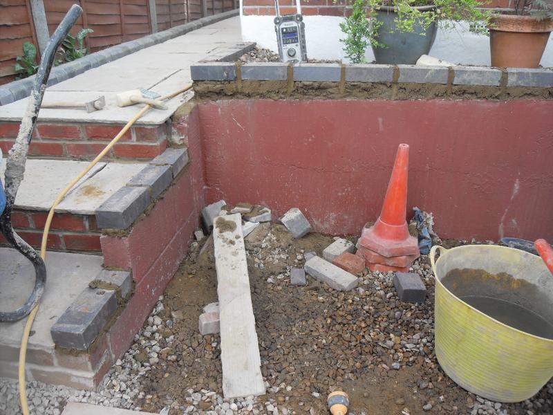 The grey engineering bricks are laid on the front wall and the steps