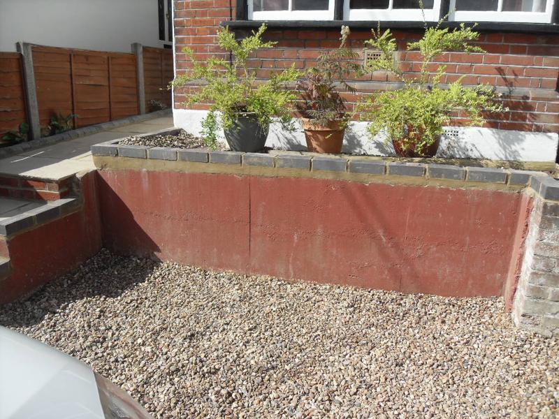 The wall with the new grey engineering bricks on top and the gravel after my husband cleaned it up